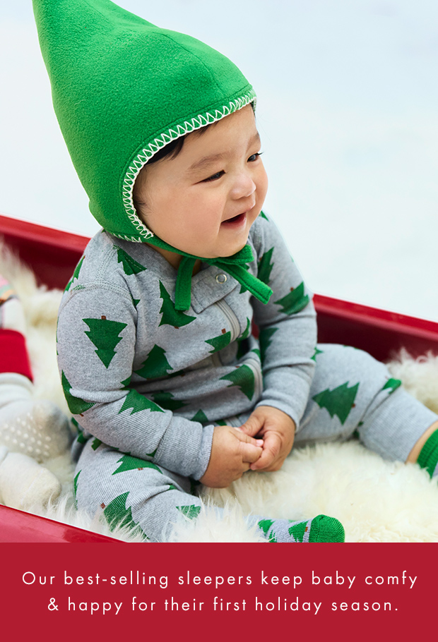 baby in tree print sleeper with a green cap